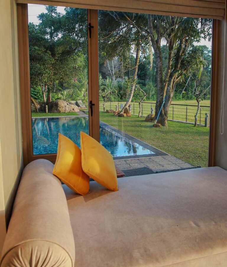 A plush seating area facing the pool at Ona Garden Villa