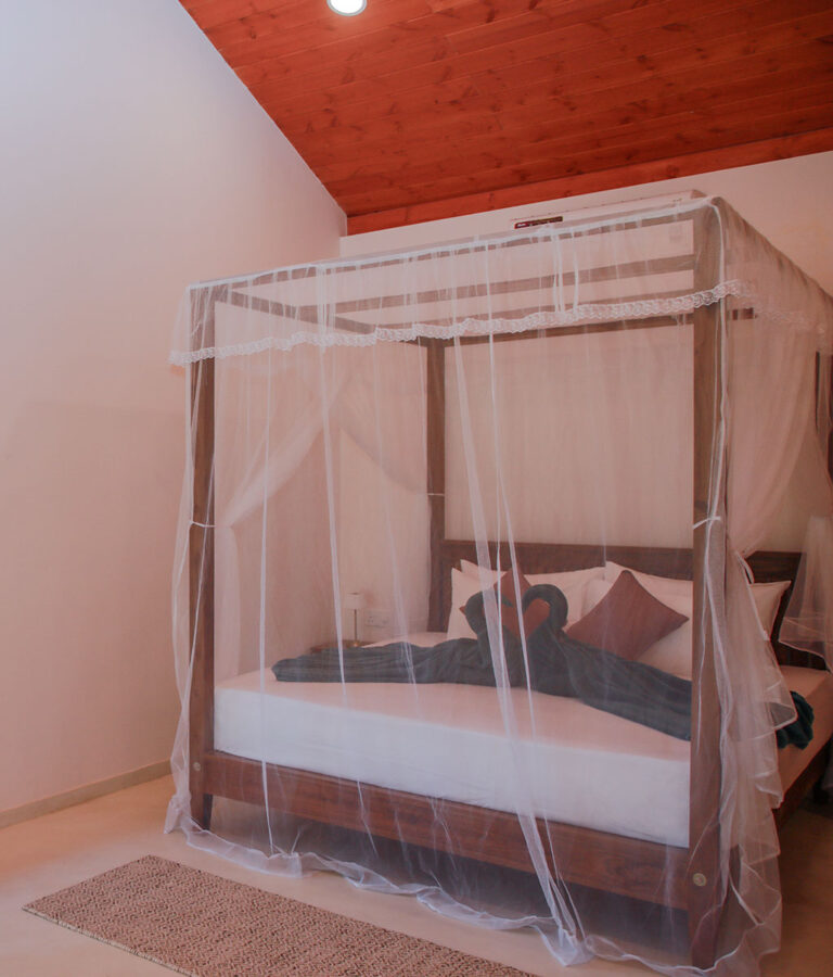 Bed with a mosquito net at Ona Garden Villa