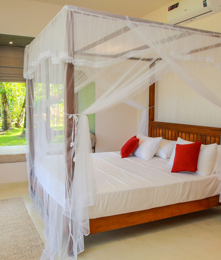 A close-up of a four-poster bed at Ona Garden Villa