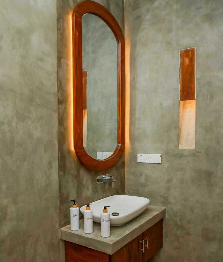 Modern mirror and a sink at Ona Garden Villa