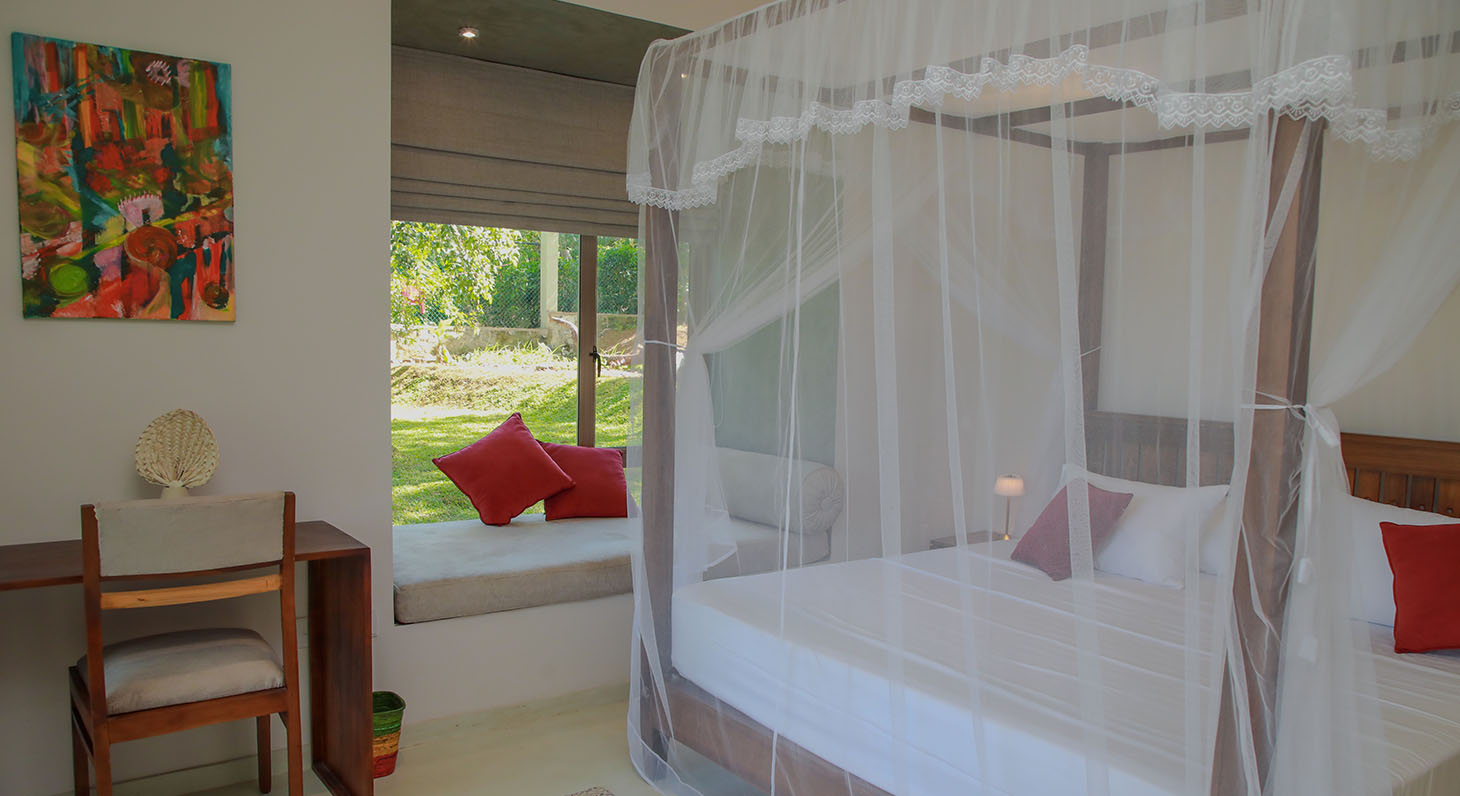 Lovi Deluxe interior with a desk and art at Ona Garden Villa